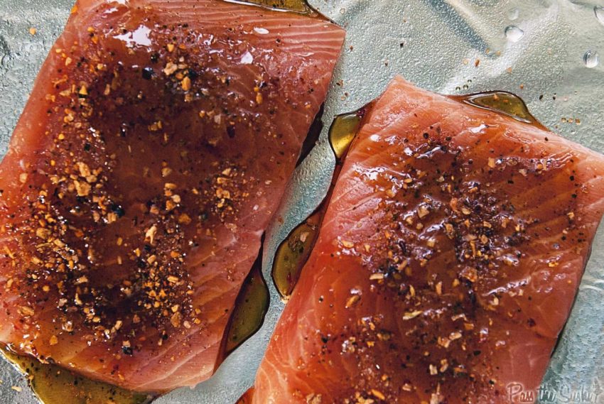 Salmon filets topped with spices and maple syrup.