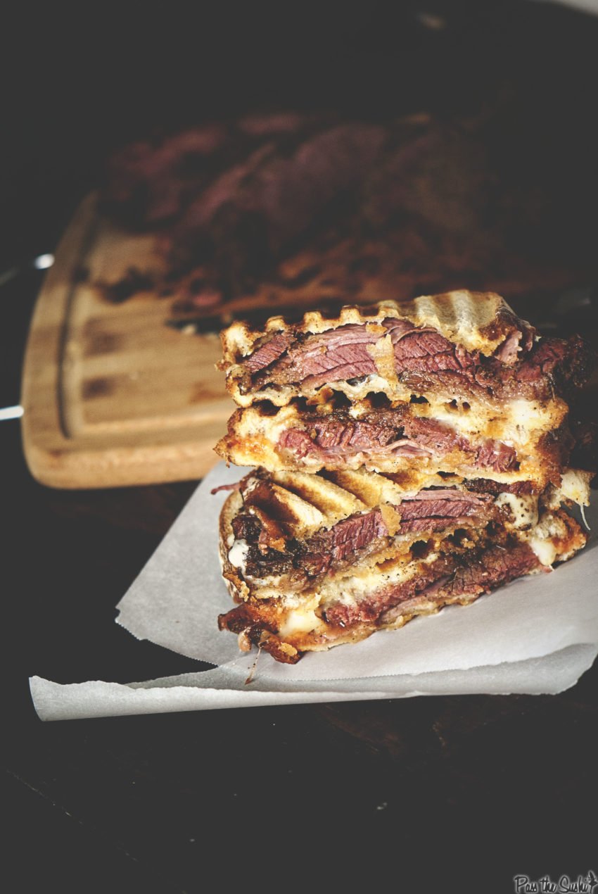 Stacked pastrami sandwich sliced in half.