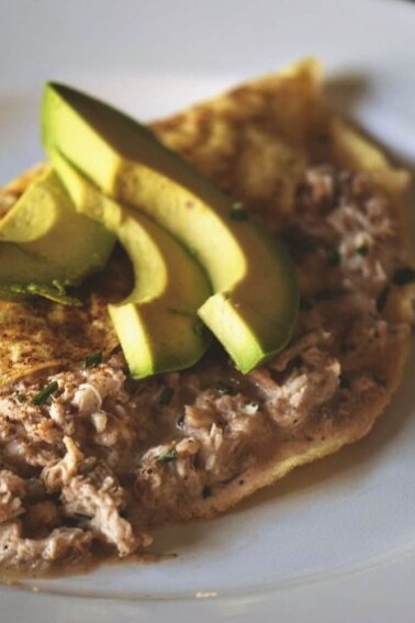 An omelet with crab and avocado on a plate.
