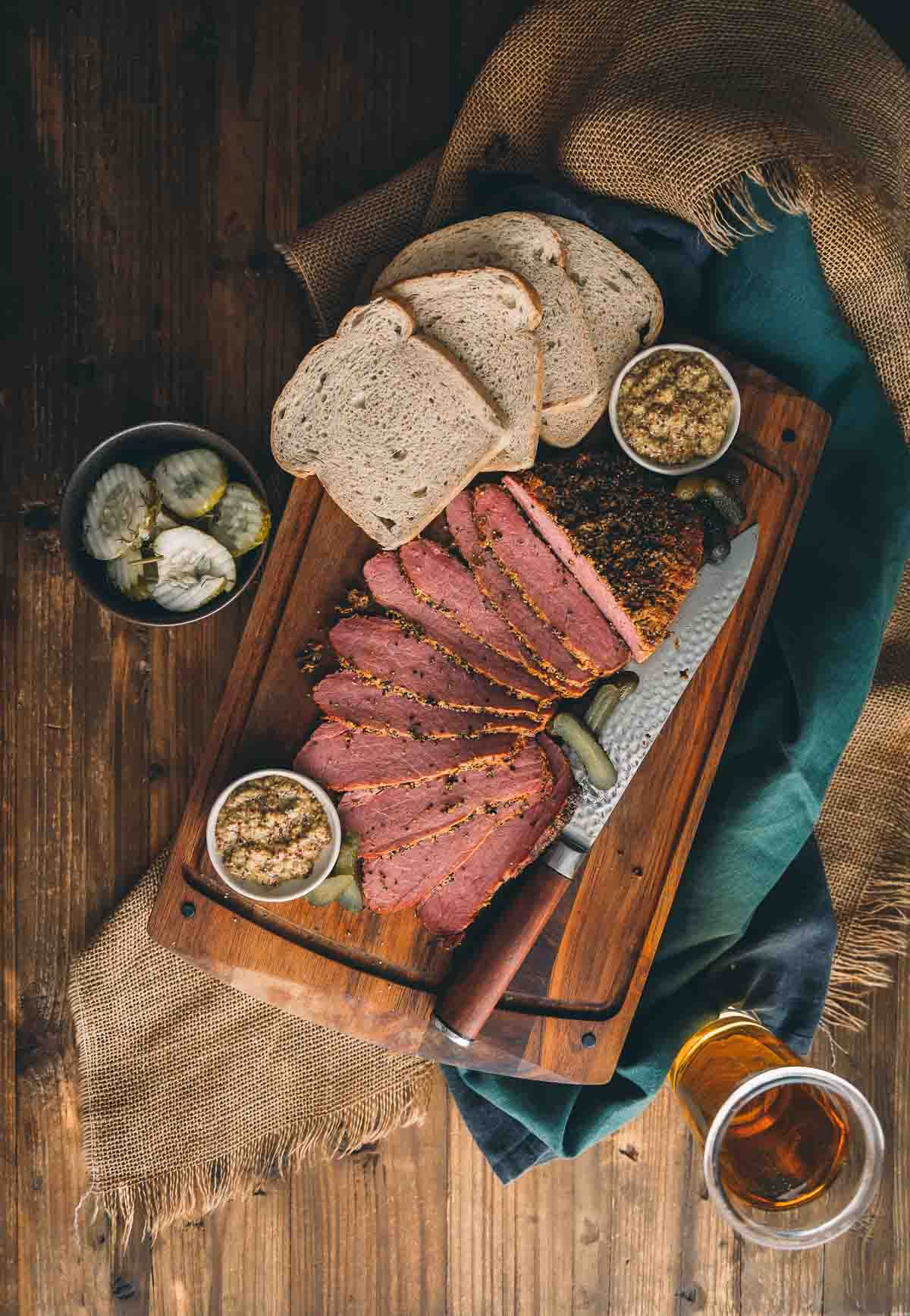 Smoked corned beef sliced on a cutting board ready to be made into a sandwich.