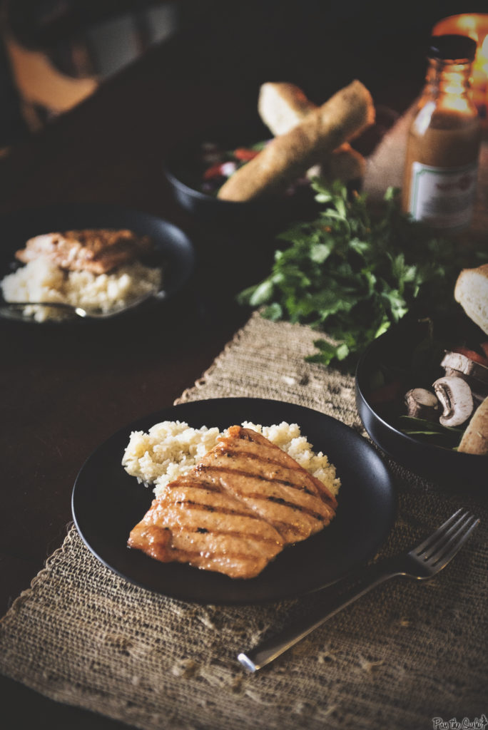 Grilled Salmon filet over rice on a black plate. The sear marks are perfect, and this is the scene I want to come home to. Yum.