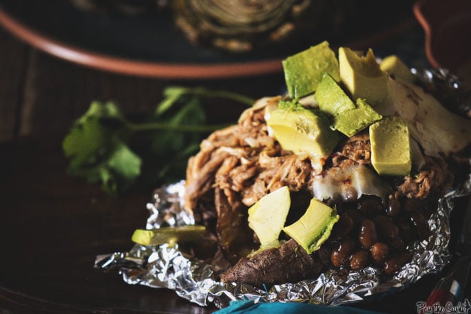 Piles of Avocado topping BBQ pork and beans, just pouring out of a sweet potato. Yeah, it's good!