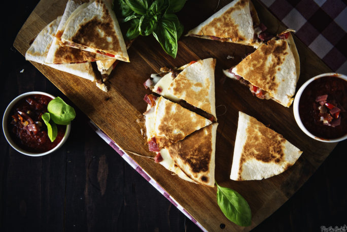 This quesadilla is all cut up and ready to go. Meat and cheese spilling out everywhere. Grab a slice, and a napkin!