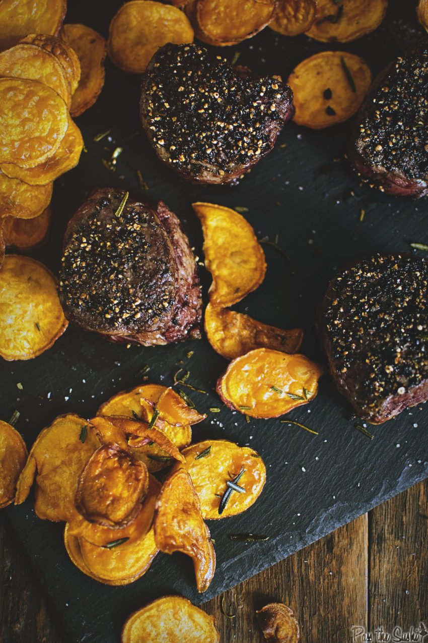 Peppercorn Crusted Filets with roasted potato slices on a black slate