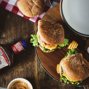 Barbecue burgers on a plate with ketchup and mustard.