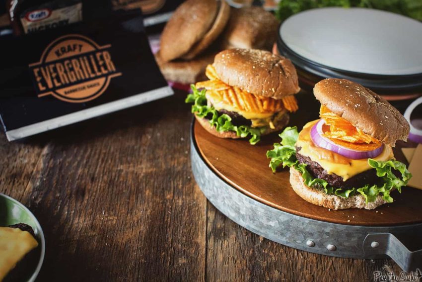 Two Cheese Burgers topped with red onions and crinkle potato chips