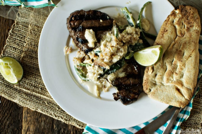 A hearty Steak covered in crab and poblanos. That huge hunk of bread on the side looks about perfect for all the juicy bits coming!