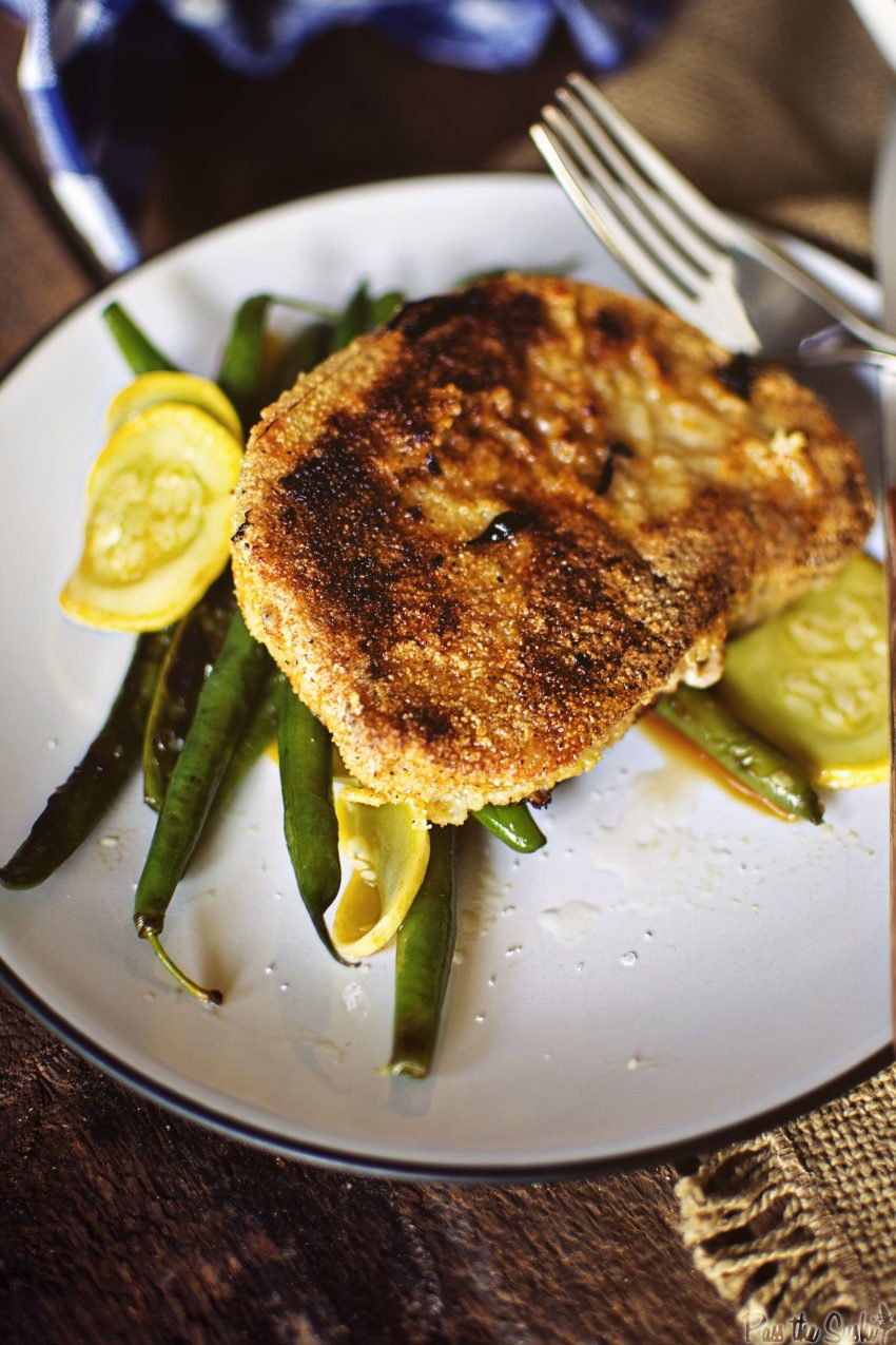 A Cornmeal crusted Pork Chop over green beans. Dig in to your new favorite meal!