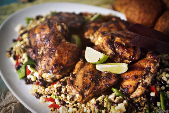 Grilled Chicken Thighs with Ancho Rub, limes and succotash on a platter. Grilled chicken was never so good!