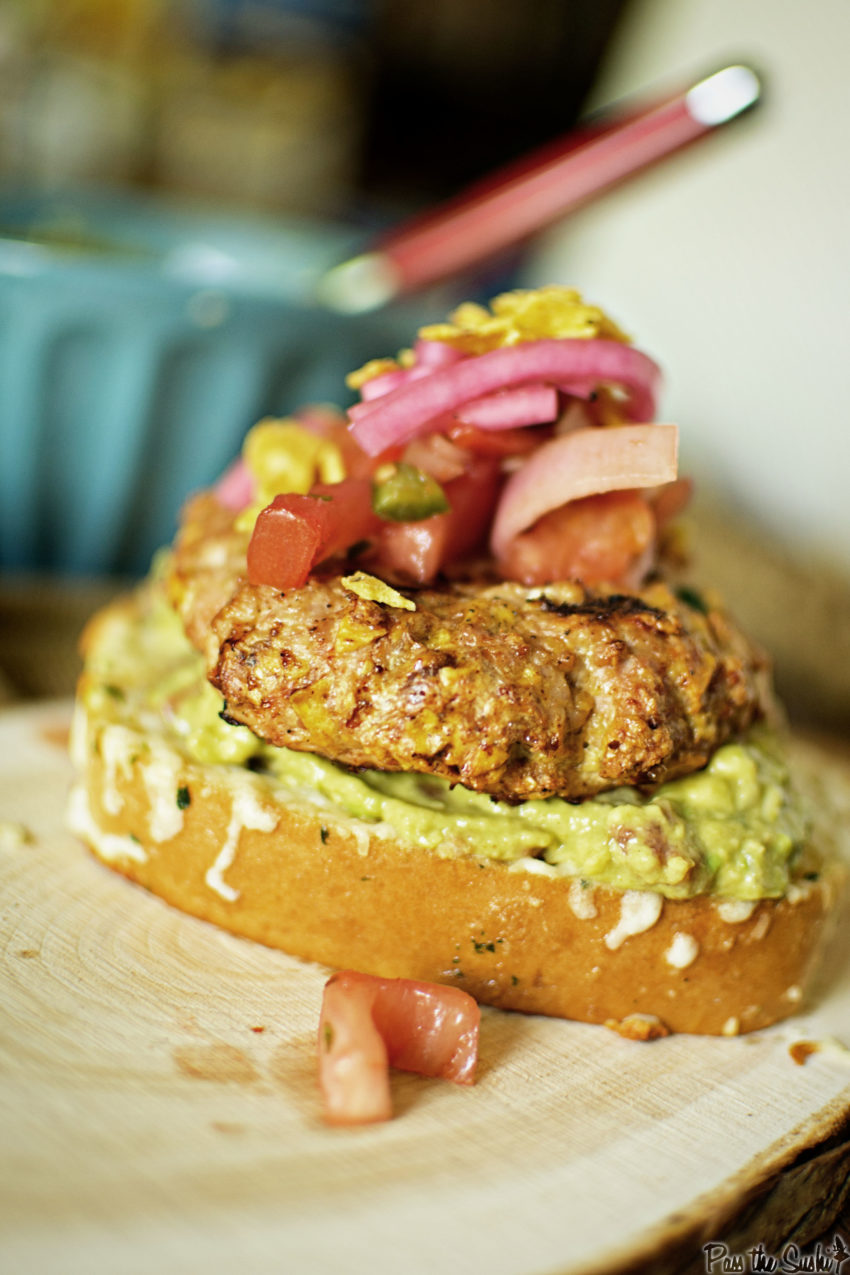 A plump chicken patty topped with tomato, red onion, and nestled on a bed of avocado smear. Yeah, this is a good one!