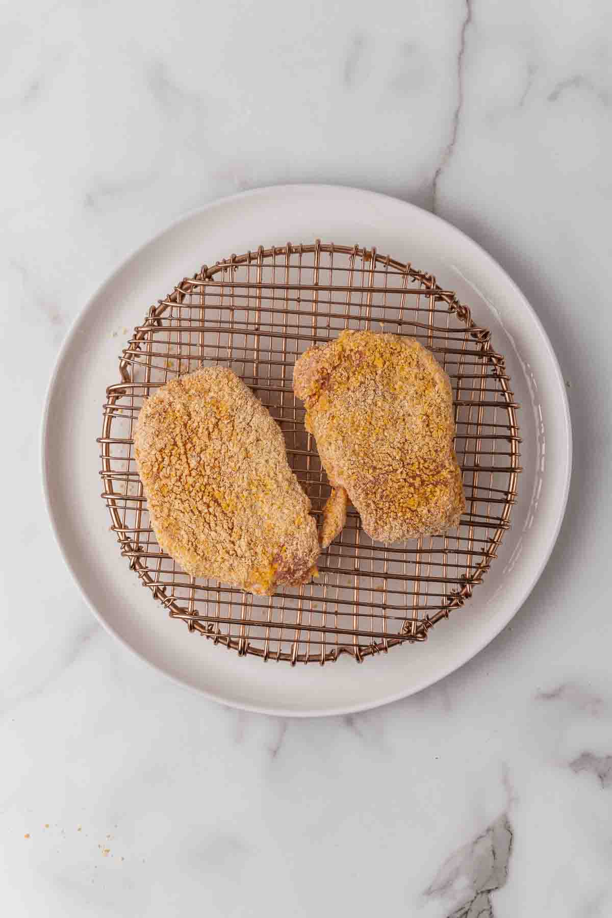 Two pieces of breaded pork chops on a plate.