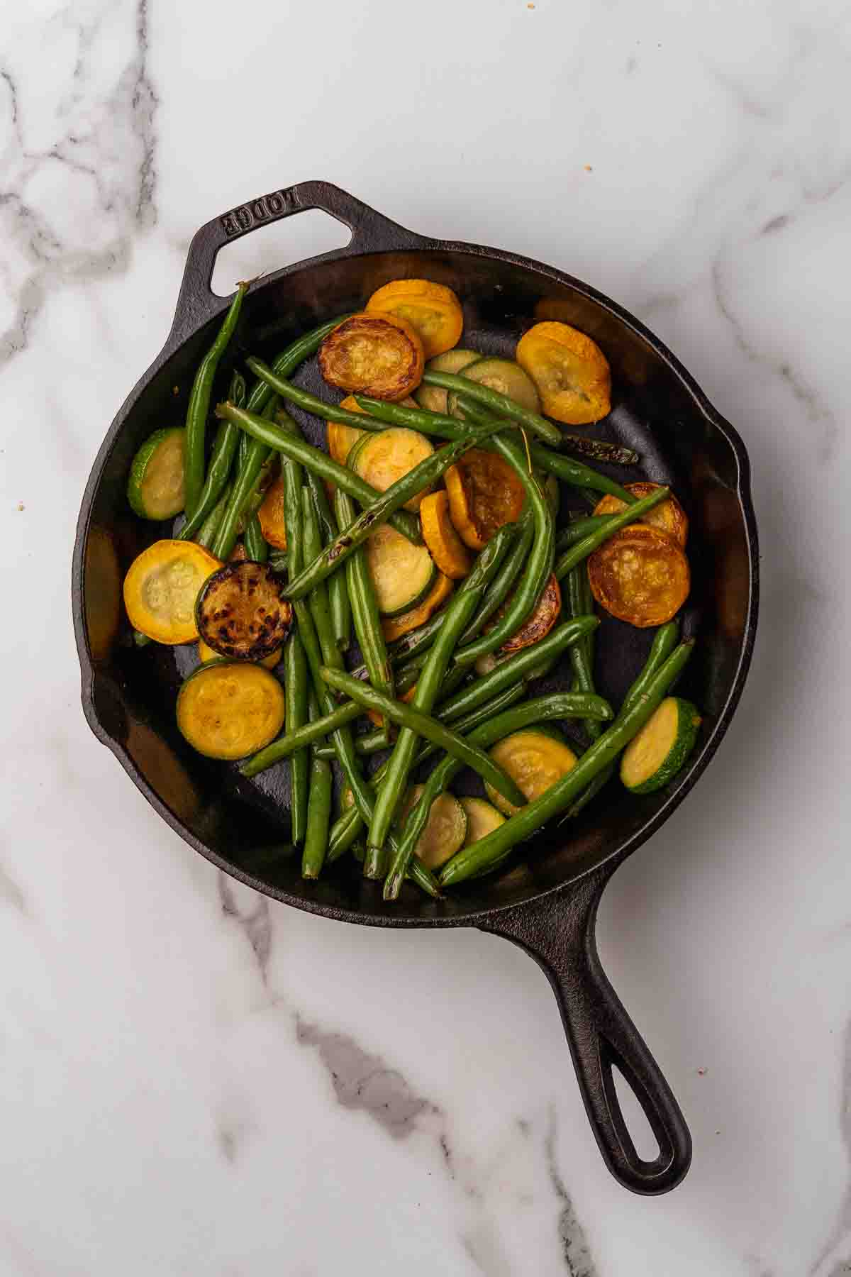 Green beans and squash in a skillet.