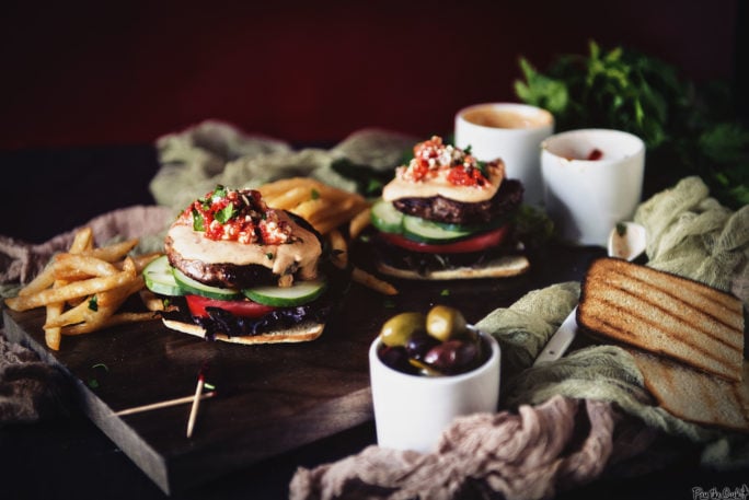 Two burger patties topped with Roasted Red Pepper Hummus and served on a flatbread. So good!