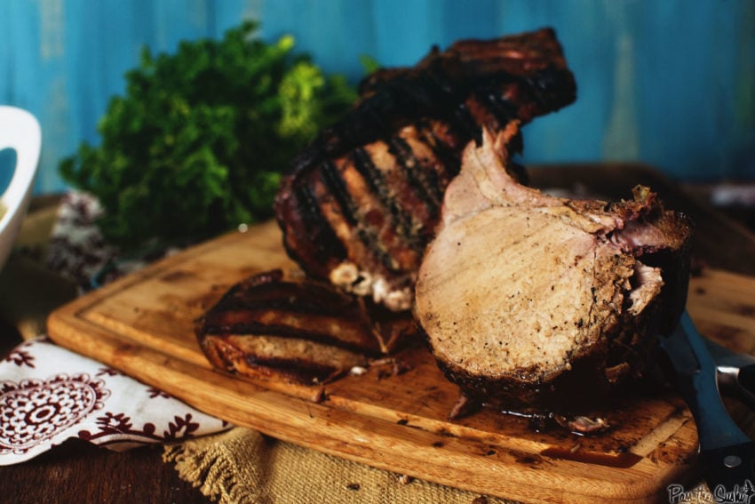 Grilled Bone-in pork roast carved to show juicy center. 