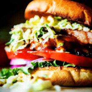 A Bison Burger topped with lettuce, tomatoes, and onions.