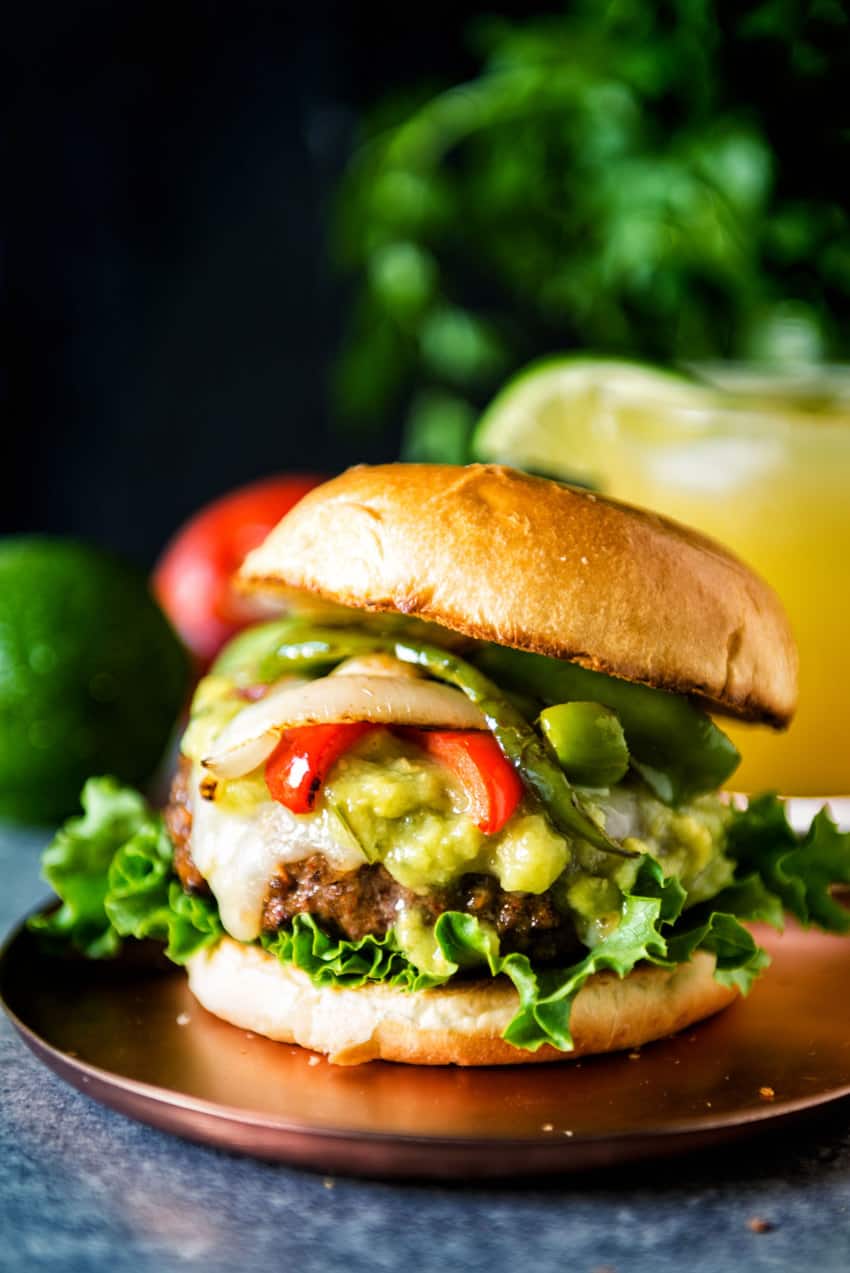 Char Grilled Fajita Burger piled high with guac, peppers and onions. Dig in! 