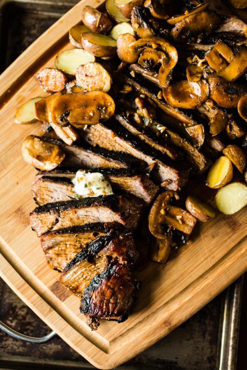 Sliced tri-tip with melting butter and mushrooms over top.