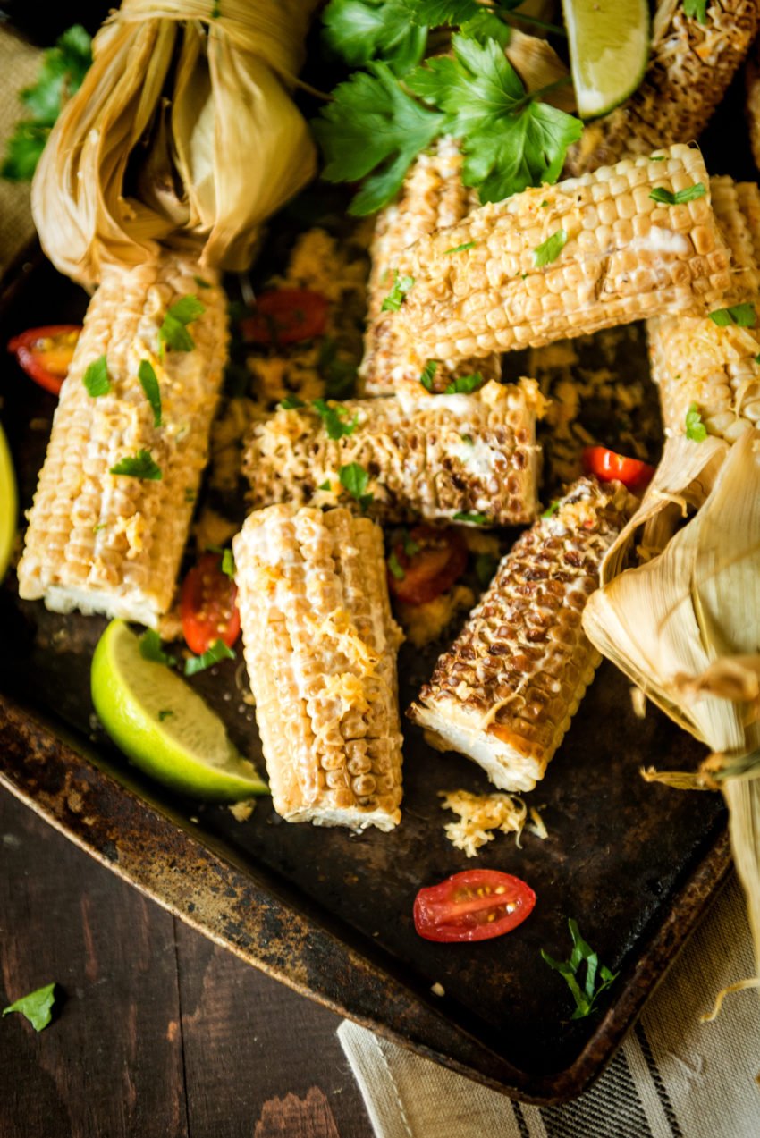 Platter of smoked corn on the cob, slathered in a simple sauce and garnished with chopped parsley. 