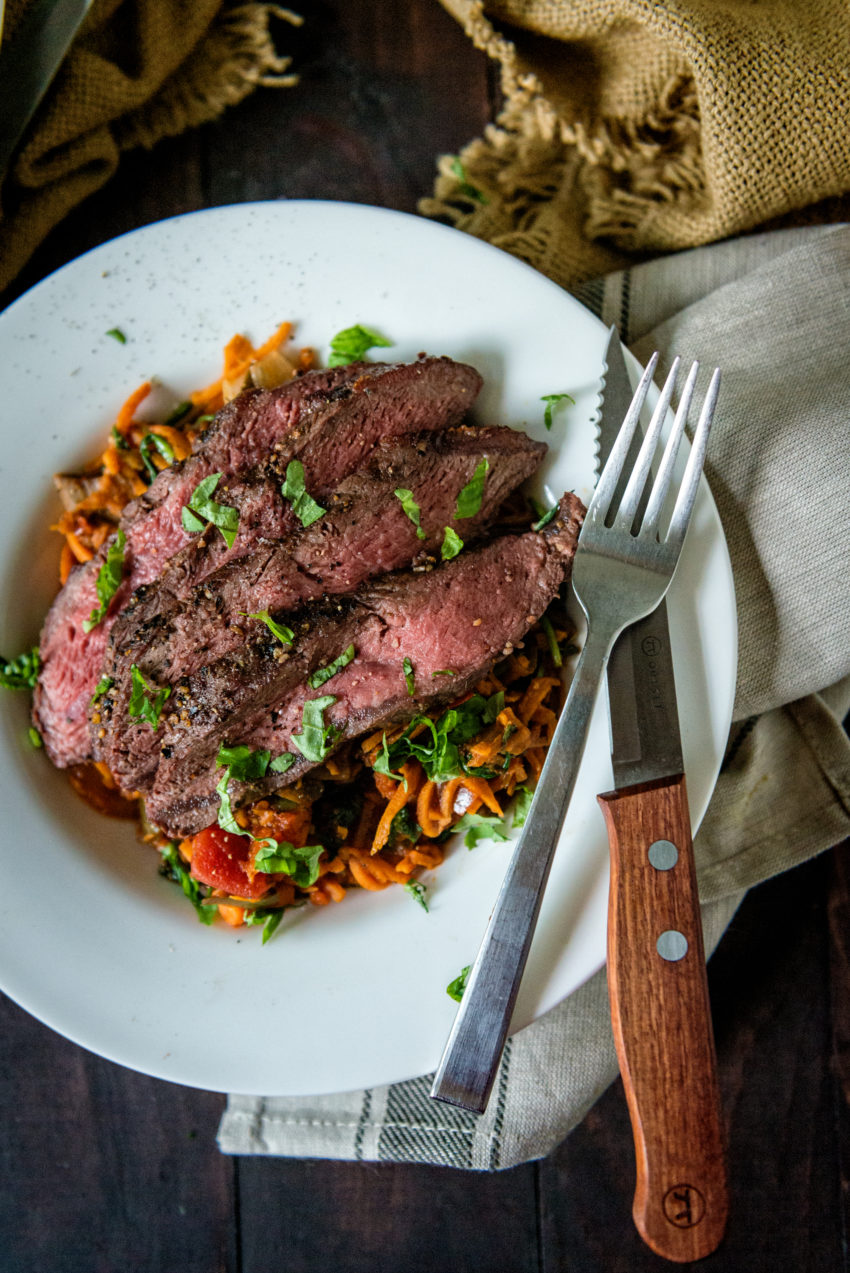 Sliced grilled flat iron steak over vegetable noodles. 