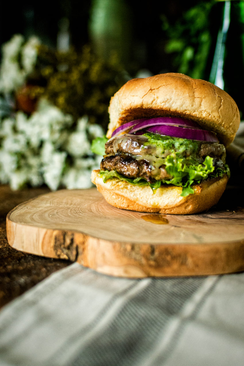 My Argentinian Chimichurri Butter Burger is just oozing flavor onto that cutting board. Dig in.