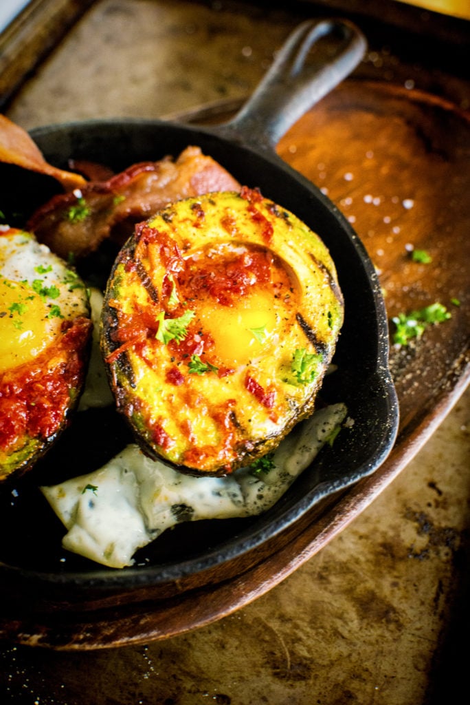 Have you ever seen a split avocado has never look better? Filled with two baked eggs, layered with Harissa, and packed in alongside some bacon, you're gonna like this breakfast!