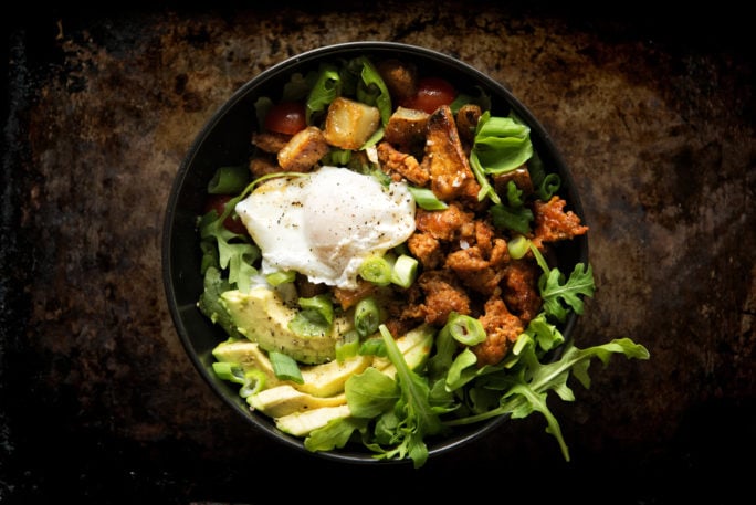 A poached egg nested on top of a bed of chorizo, avocado, home fries and arugula. You've got to try this!