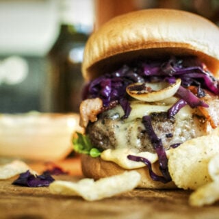 Thick Irish Brat Burger with cabbage braised in beer, onions, bacon, and chips