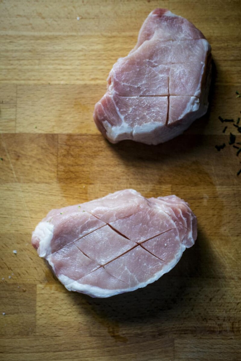 Pan-seared pork chops on a wooden cutting board.