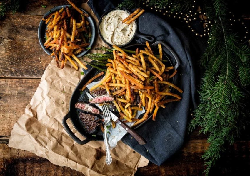 Steak Frites with Rosemary Duck Fat Fries, a bowl of dipping sauce, and all served in a cast iron platter.