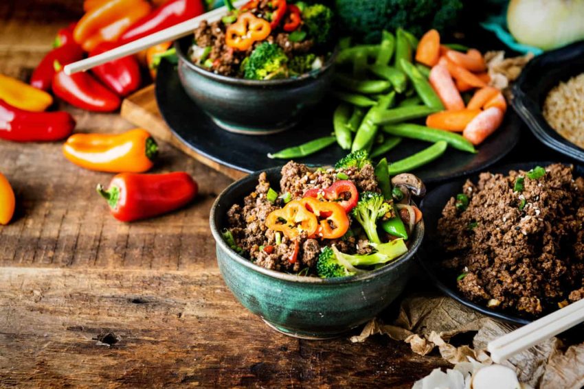 Beef and veggies piled together in a bowl, tons more of everything laid out. Look at those peppers! This is a fresh, healthy meal that will seriously fuel you up!