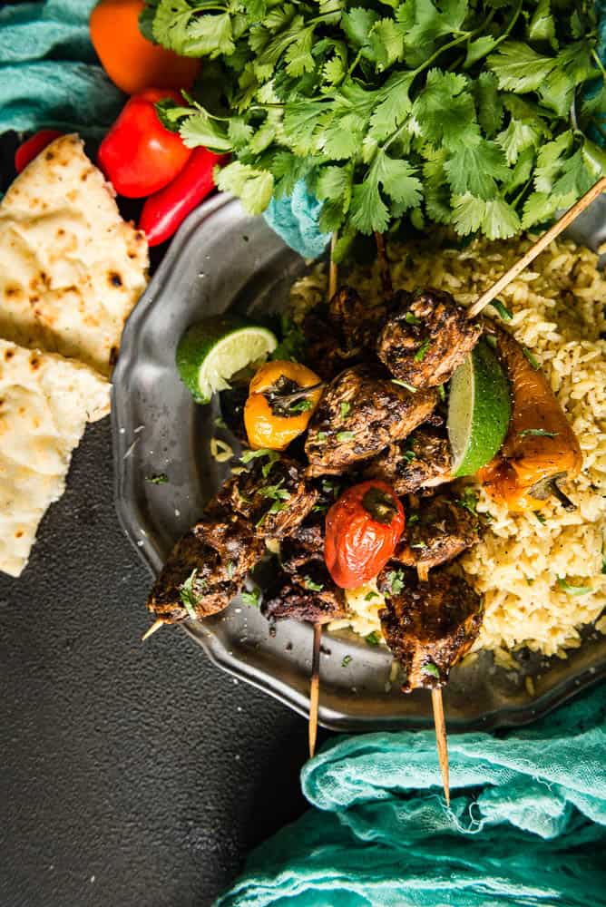 Tasty quick chicken kabobs over rice with charred peppers and lime