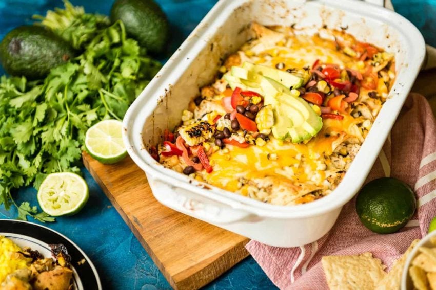 Limes, Whole avocados and cilantro scattered about. A white platter filled with goodness. Fresh sliced avocado, peppers, tomatoes and cheese coat this platter of enchiladas. Inside, smoked Alaskan Halibut. yeah. this is good.