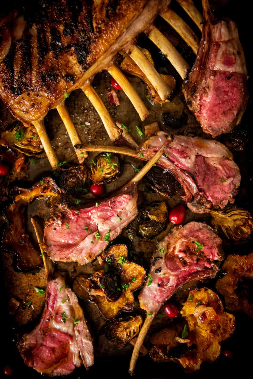 Perfect Grilled Rack of Lamb on board with veggies.