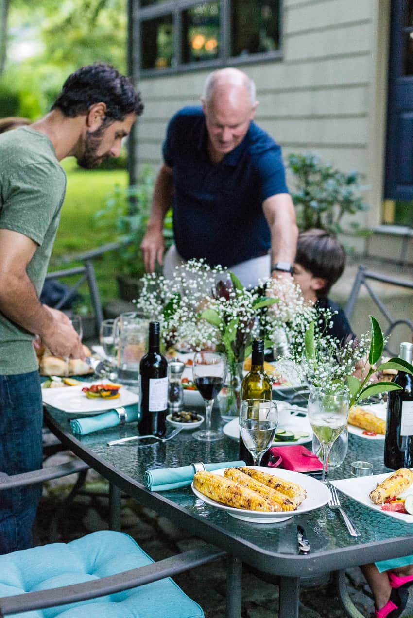 A group of people preparing lamb burgers at an outdoor table.