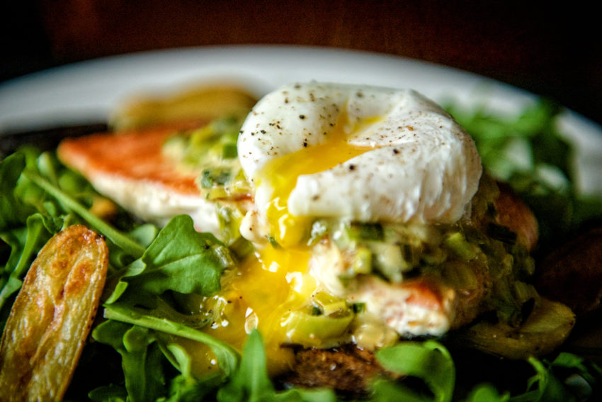 Salmon pan-seared with crisp skin and flaky interior on a white plate.