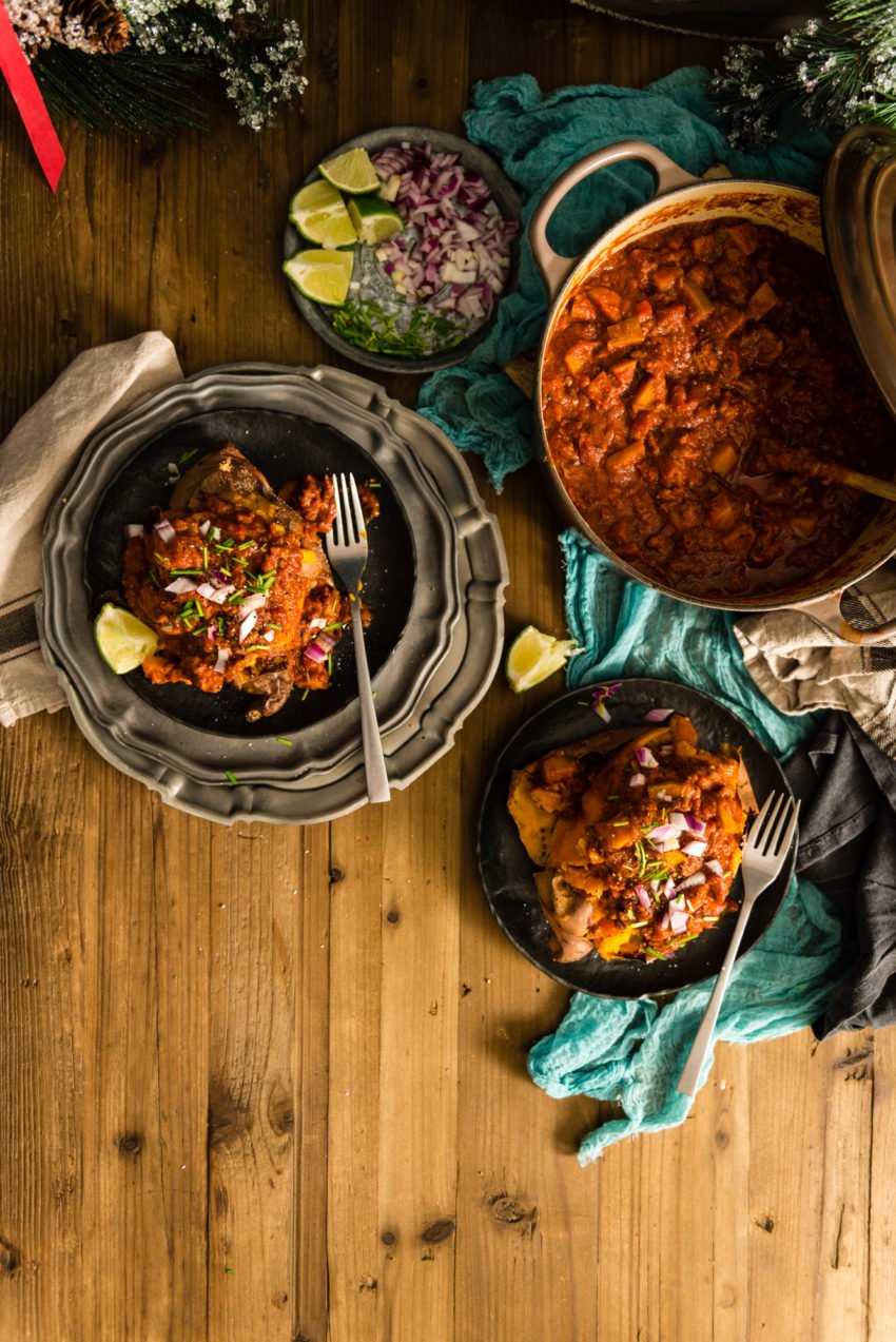 A heavy cast iron pot of chili. A plate of toppings. And two sweet potatoes on plates that have be absolutely buried in this amazing meaty mess. So good!