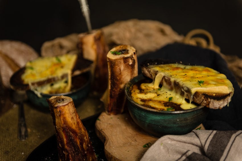 Rich French onion soup topped with sliced French bread and melty cheese dripping down the sides. 