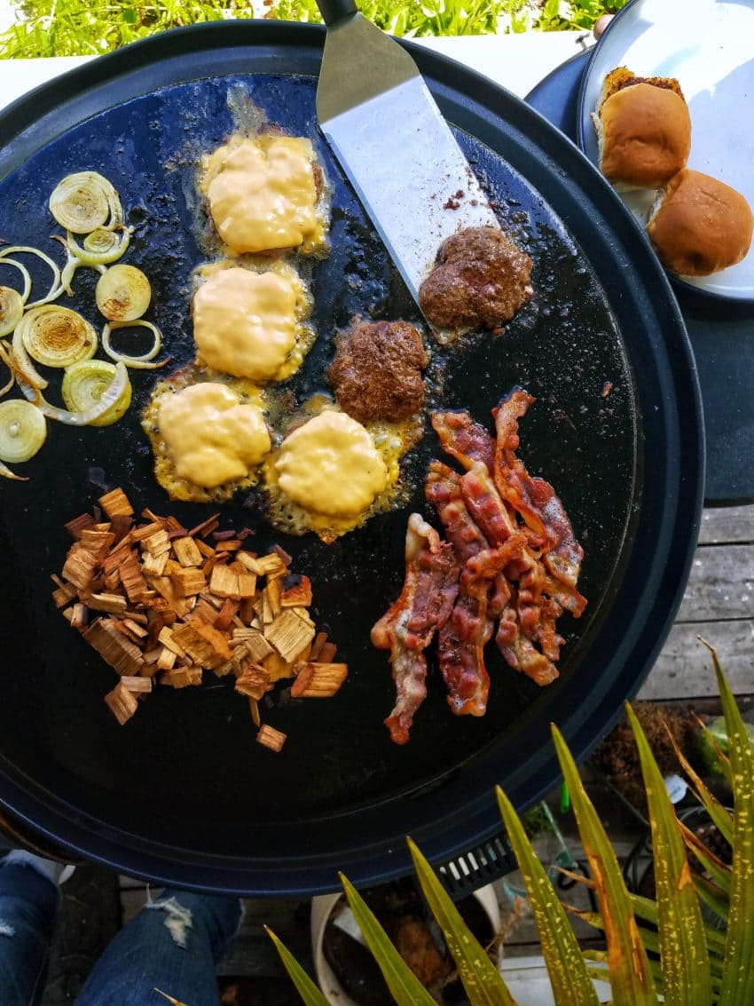 Flat top griddle with fixings for a smashburger.