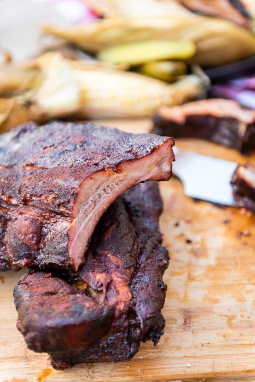 Close up of smoked pork loin back ribs showing a beautiful pink smoke ring along the edge and delicious spicy bark.