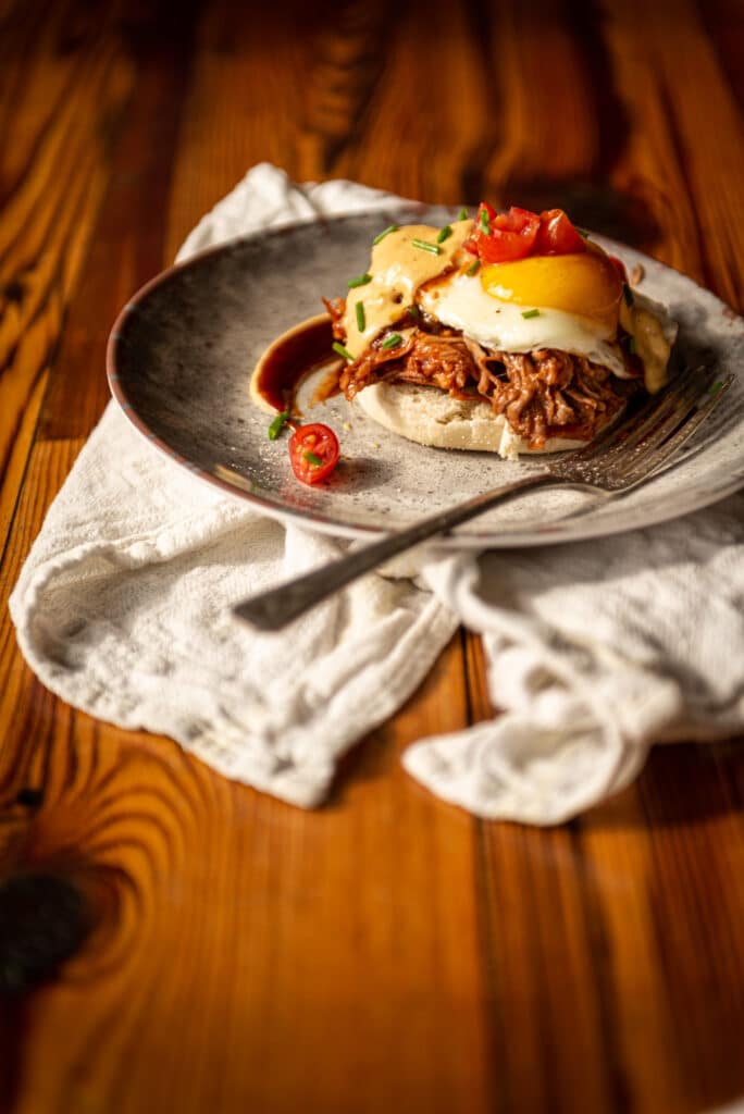 side view of plate filled with pulled pork eggs benedict