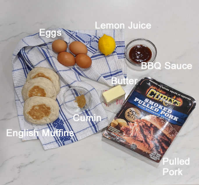 overhead ingredient shot for bbq eggs benedict; muffins, eggs, lemon, butter, cumin, bbq sauce, and pulled pork in packaging