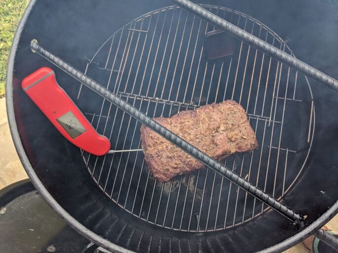 thermapen inserted into the beef over smoker to see internal temp