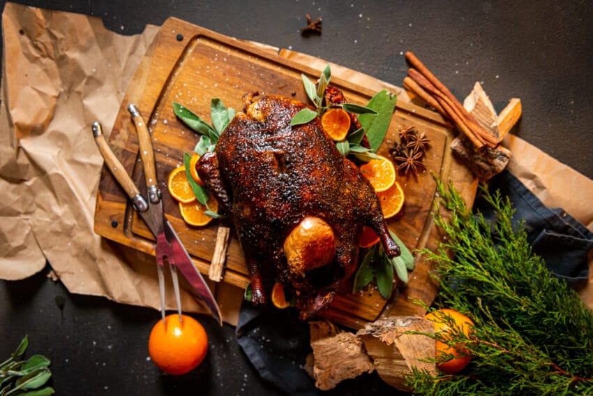 smoked duck on platter with sage and sliced oranges