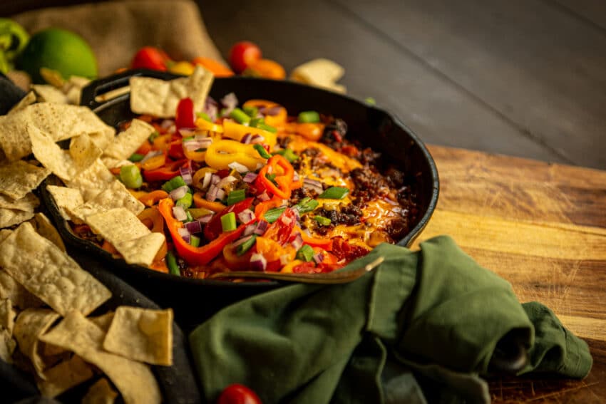 There is nothing more inviting than hot cheesy dip in a skillet waiting for that first chip! This has tons of fresh peppers, tomatoes and onions on top with a mountain of chips just begging to be devoured.