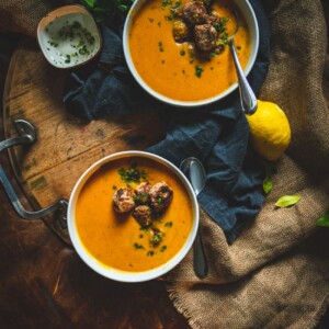 Big bowls of carrot soup with turkey meatballs and parlsey garnish