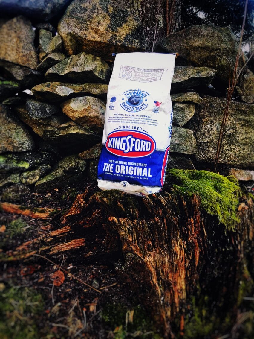 bag of kingsfod charcoal on a tree stump