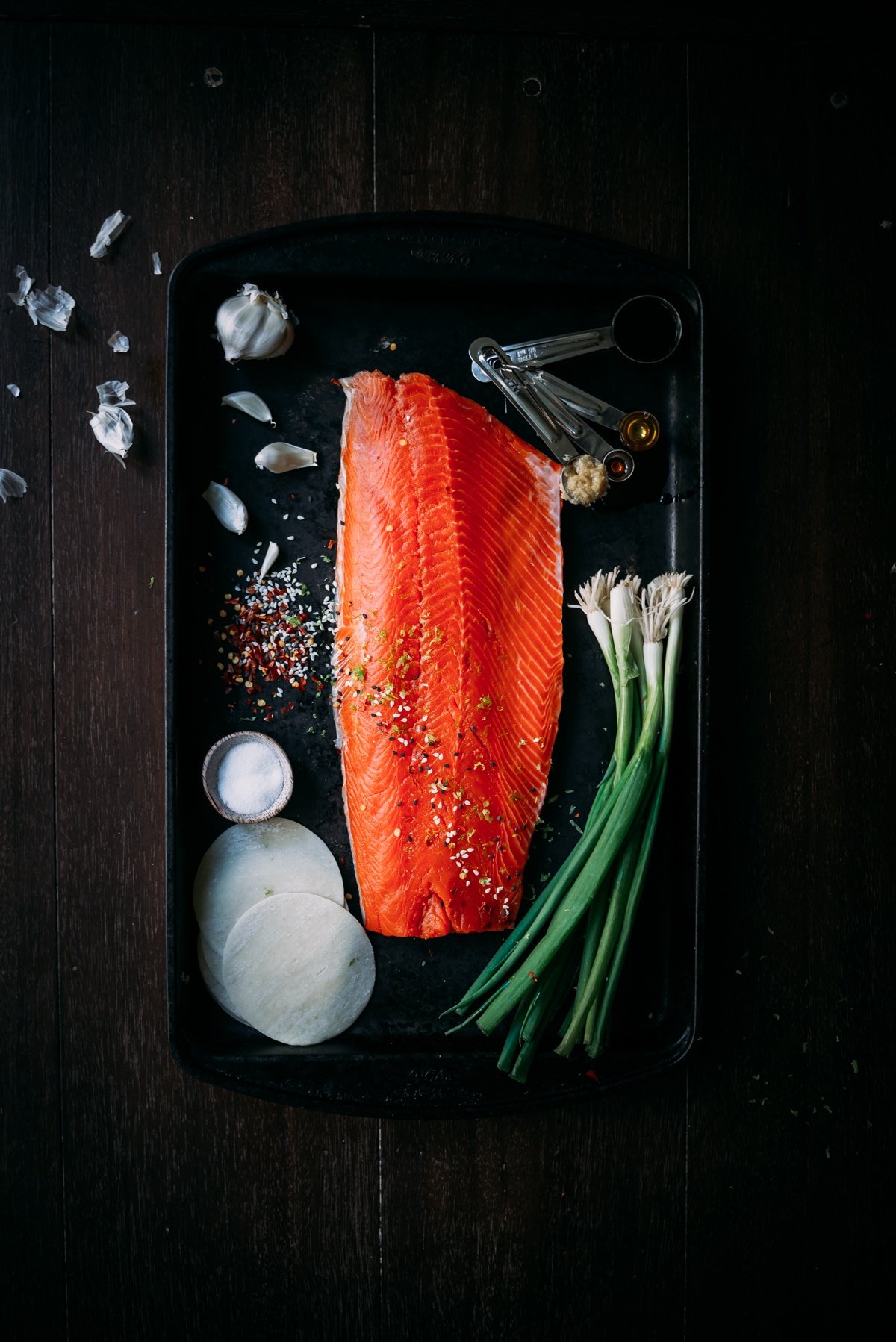 Fresh sockeye filet on platter with scallions, dumpling wrappers and ingredients 