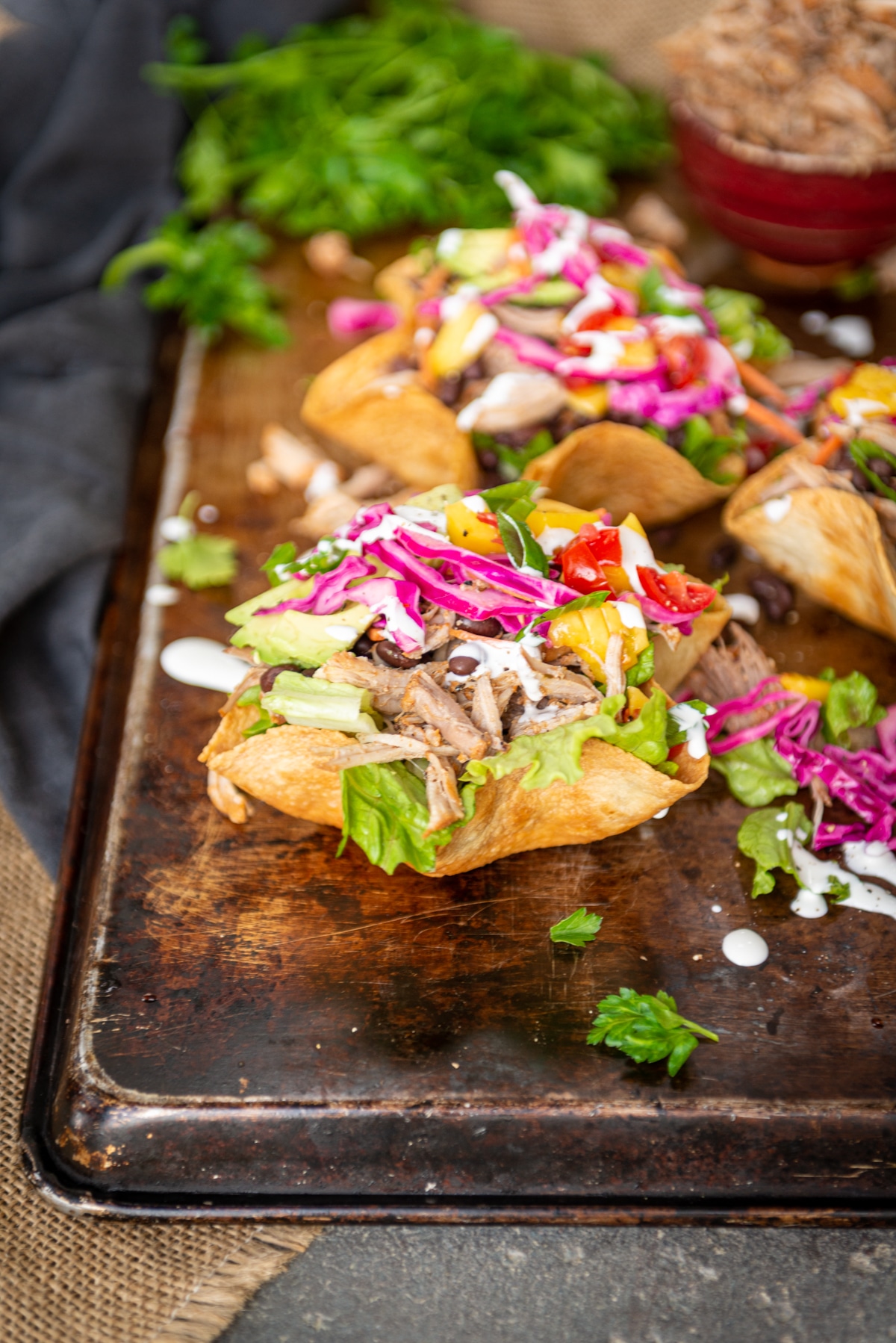 Close up of a loaded pulled pork carnitas bowl with fresh avocados, mangos, pickled cabbage toppings 