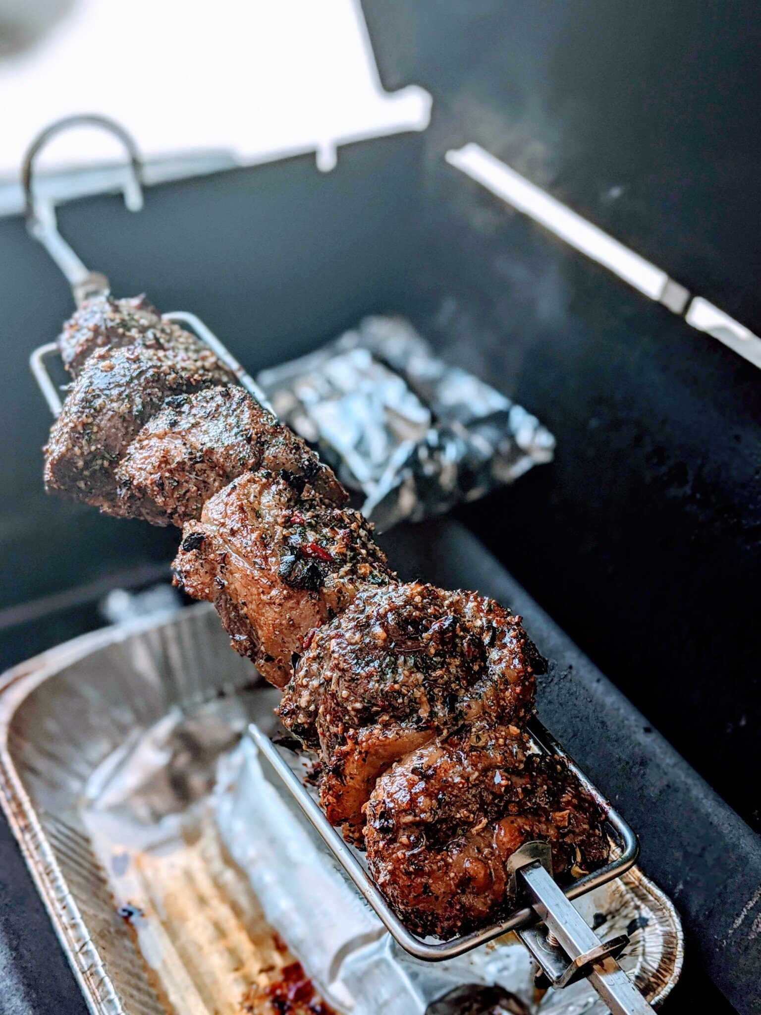 picanha roasting on rotisserie on gas grill 