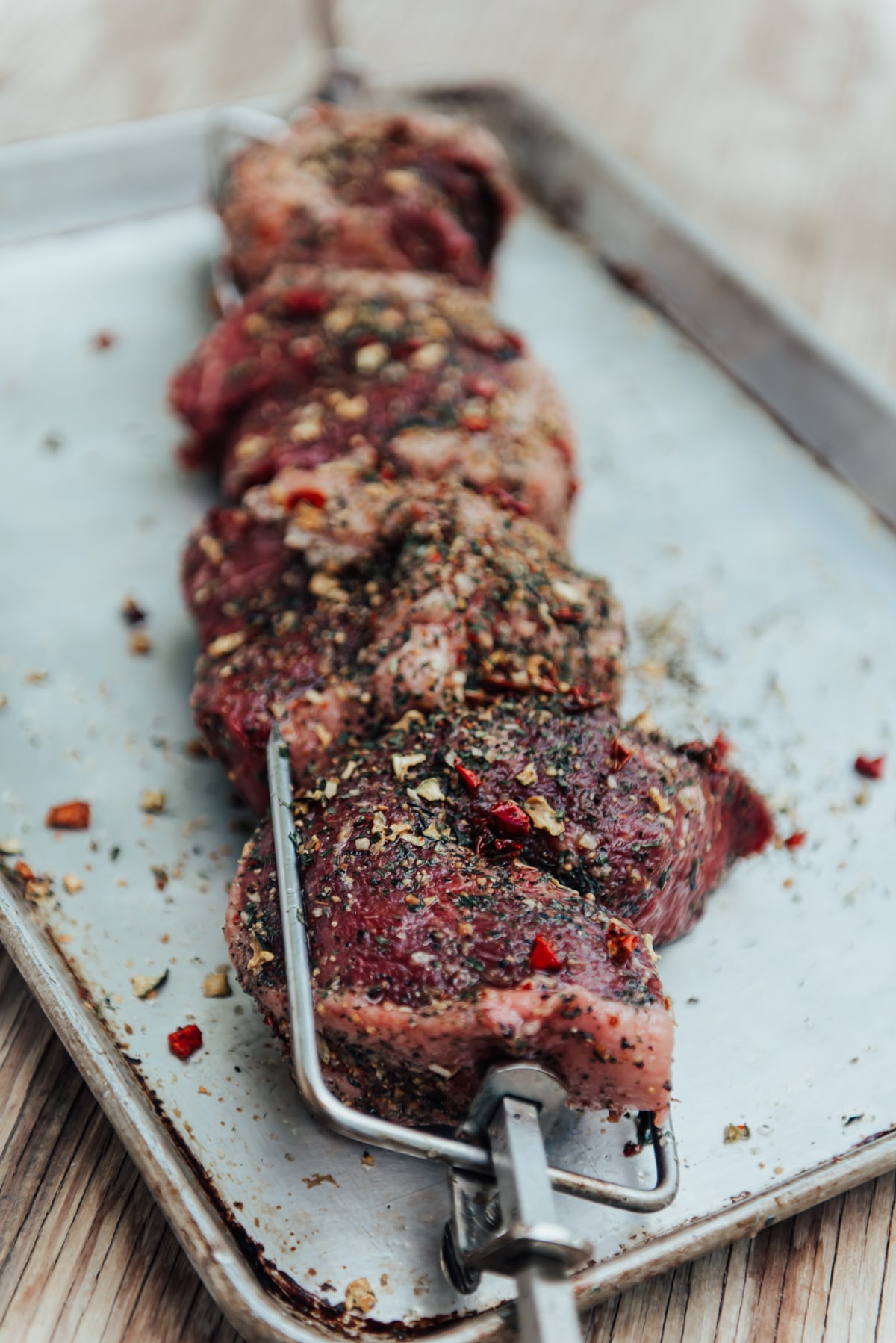 Cut portions of picanha folded into a C shape and skewered ready for rotisserie grilling.